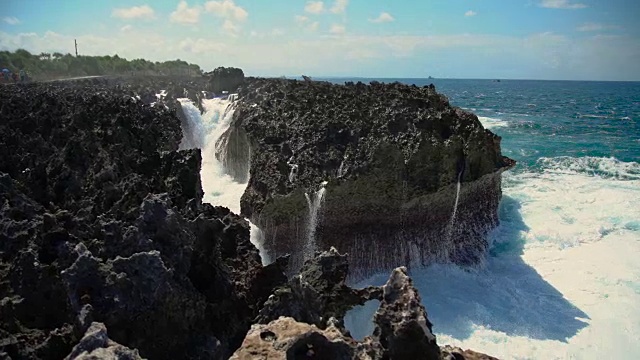 强烈的海浪拍打着多岩石的海岸视频素材