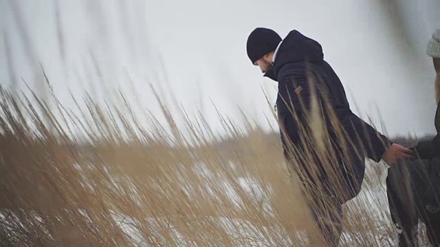 一对恋人在田野里走过厚厚的积雪视频素材