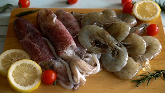 新鲜的生海鲜(虾、鱿鱼)放在木板上视频素材