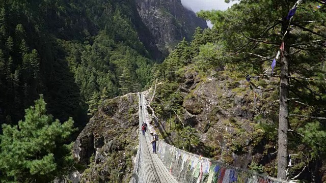 一群徒步旅行者穿过吊桥。视频素材