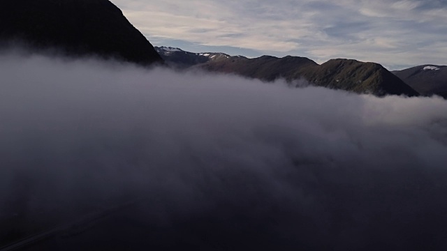 4K鸟瞰图上的山剪影在森林与雾在挪威视频素材