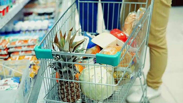 guy and girl choose products in the supermarket / Couple in supermarket /年轻夫妇在超市购物视频素材