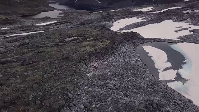 4K鸟瞰岩石，雪，和森林俯瞰水和山峰视频素材