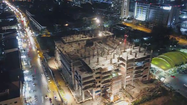 4k延时:建筑工地上起重机和工人在夜间的鸟瞰图视频素材