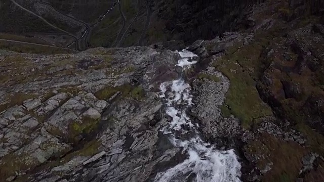 4K鸟瞰图的瀑布流过悬崖山的特洛斯提根山谷视频下载