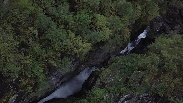 4K鸟瞰图瀑布与树木流动在挪威的森林视频素材