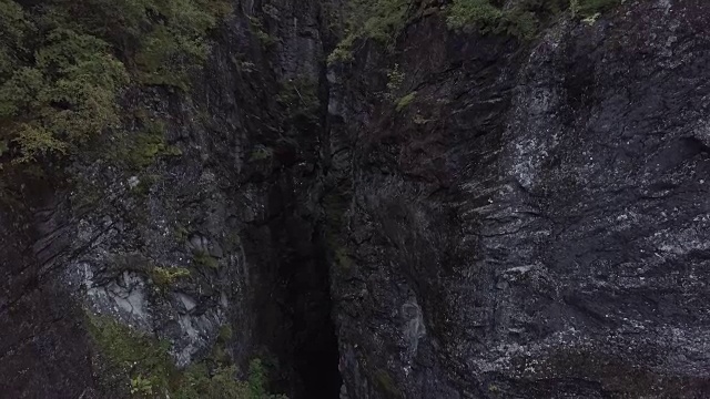 4K鸟瞰图悬崖山与黑暗山谷之间的一边。树木和森林视频素材