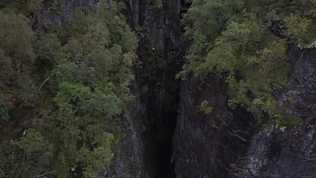 4K鸟瞰图激流瀑布通过深史诗山谷的岩石和森林视频素材