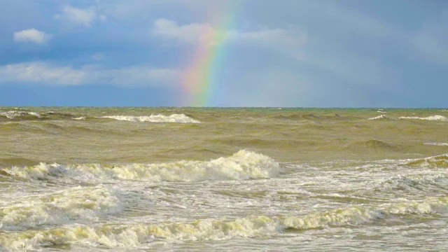 日落时和雨后的海上彩虹。清晨风雨交加的海面上出现了彩虹视频素材