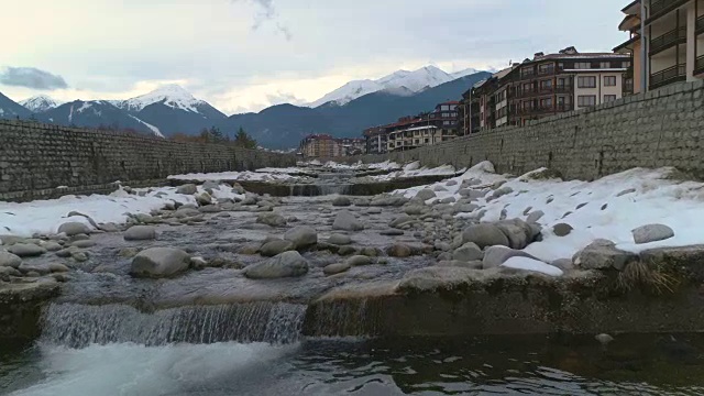 以皮林山脉为背景的慢镜头无人机低空飞过冬天的河流视频素材