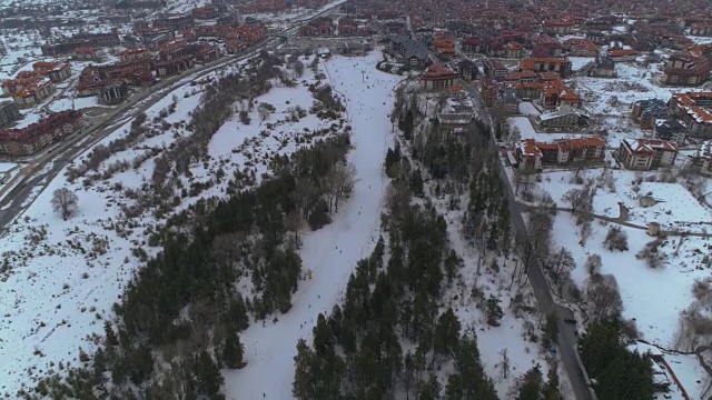 无人机下降显示在班斯科，保加利亚冬季旅游胜地滑雪斜坡视频素材