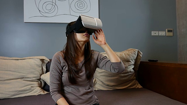 女性在家里使用手机VR头盔视频素材