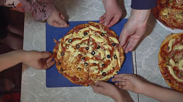 俯视图，不认识的成年人和孩子吃披萨片。视频素材