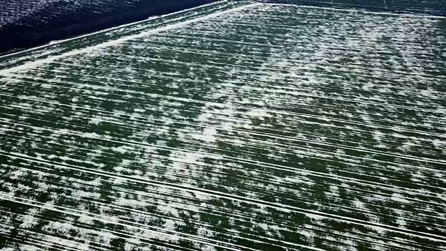 春季鸟瞰图中被雪覆盖的谷地。视频素材