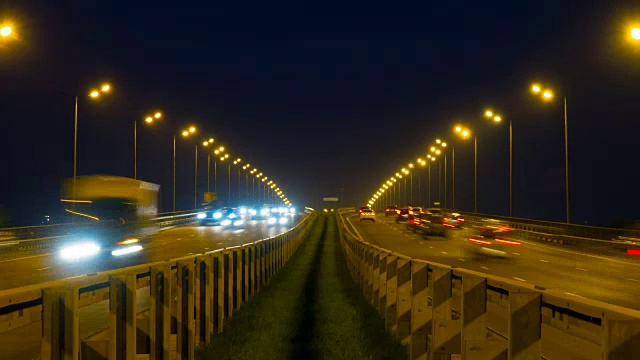 公路交通车辆在夜间时间流逝。汽车行驶在道路上的桥晚上延时。4 k UHD视频素材