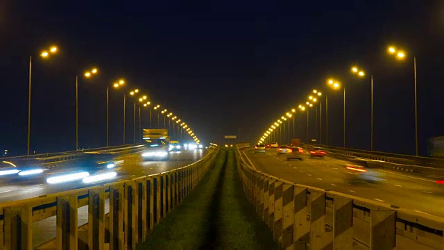 公路交通车辆在夜间时间流逝。汽车行驶在道路上的桥晚上延时。4 k UHD视频素材