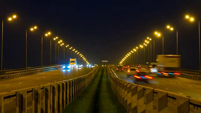 公路交通车辆在夜间时间流逝。汽车行驶在道路上的桥晚上延时。4 k UHD视频素材