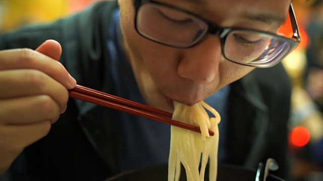 饥饿男子吃面条拉面的特写视频素材