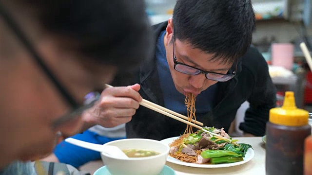 男人们吃炒面和煮猪肝，香港，中国食物视频素材