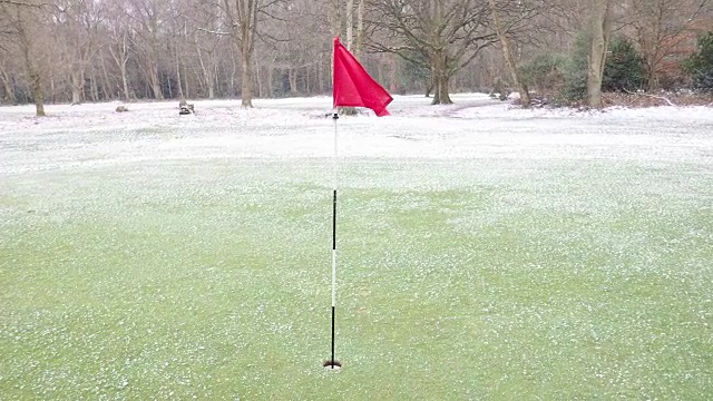 高尔夫球洞旗子在风和雪视频素材