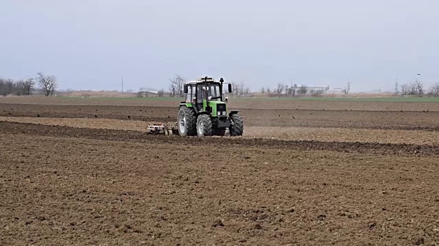 播种前要把地里的土壤弄松。拖拉机用犁犁地视频素材