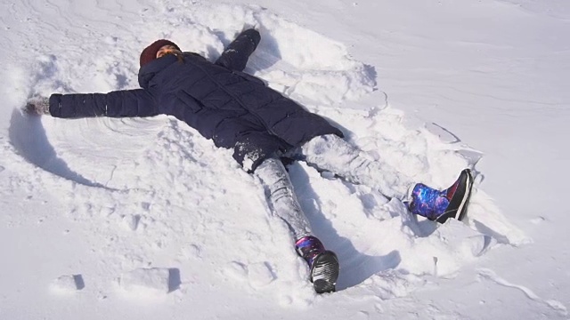 美丽的年轻女子在做雪天使视频素材