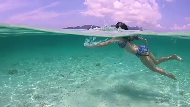 水下:可爱的女孩或有黑色长发的亚洲妇女在水下游泳视频素材