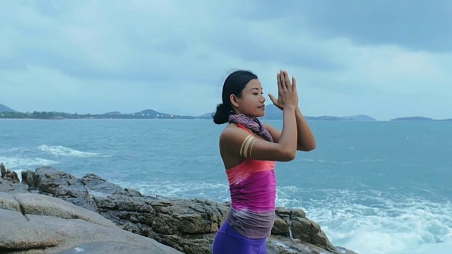 女子练习瑜伽体式敬礼太阳Surya Namaskar在海岸视频素材