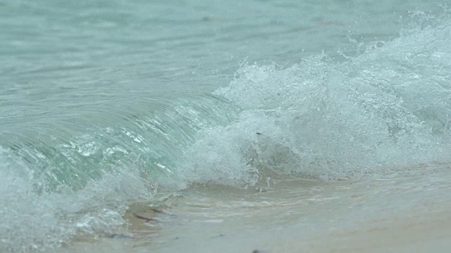 慢镜头:小桶海浪冲刷着美丽的异国情调的白色沙滩。视频素材