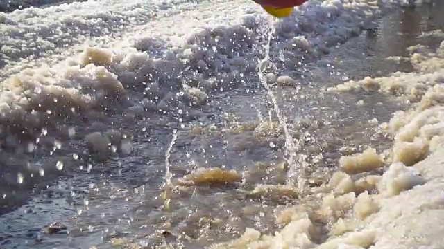 穿着雨靴在冰坑里跳的孩子视频素材