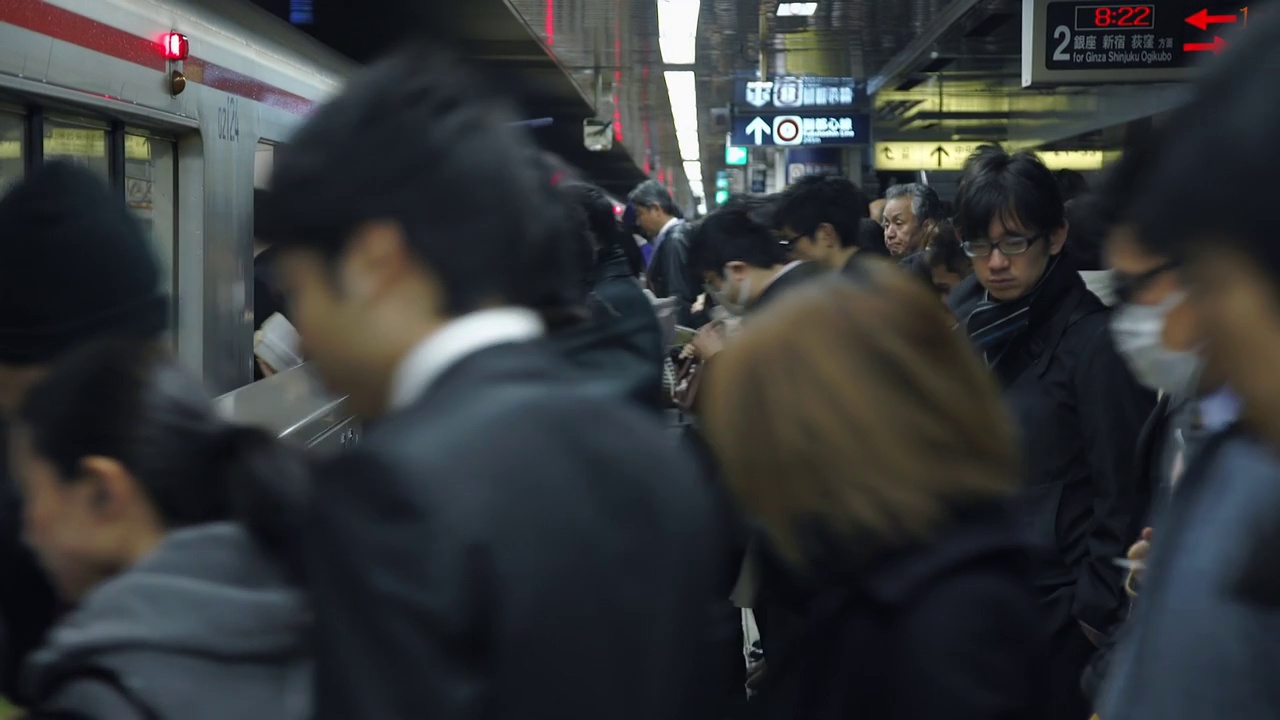 拥挤的人群在高峰时间进入地铁——日本东京视频下载