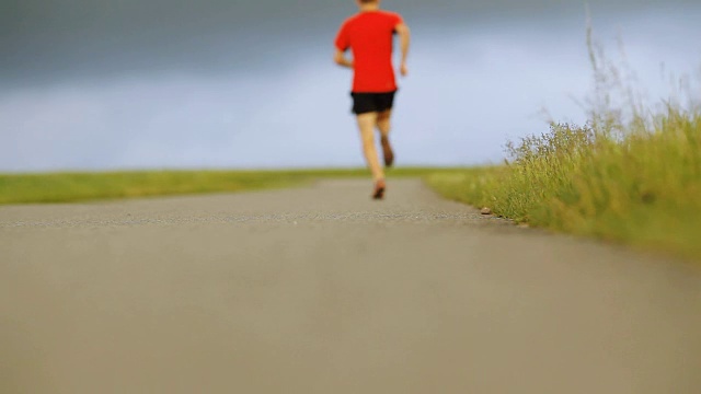 在乡村路上奔跑的男人。慢跑动机在美丽的鼓舞人心的风景。视频素材