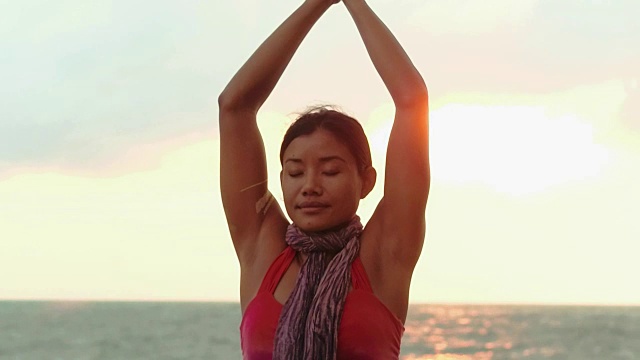 亚洲女人沉思在海滩上的晚上瑜伽训练视频素材