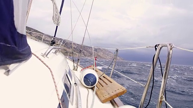 帆船在波涛汹涌的海面上，实时航行视频素材