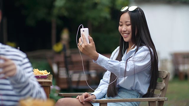 漂亮的亚洲女人通过智能手机视频通话视频素材