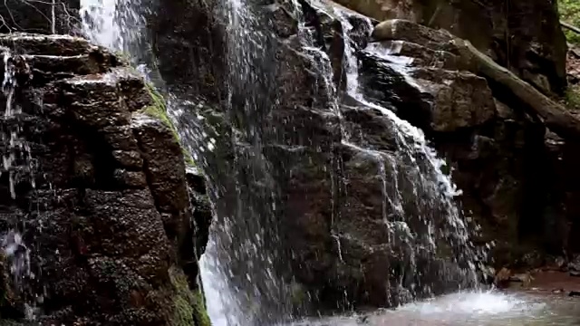 美丽的瀑布在岩石山。在野生森林里，水往山下流视频素材