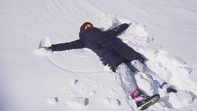 美丽的年轻女子在做雪天使视频素材