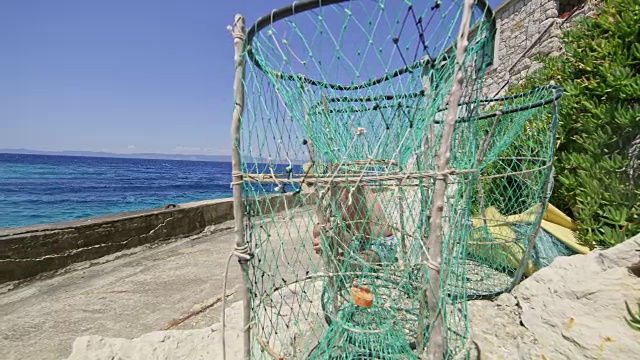 在阳光明媚的夏日海洋码头上，渔民在渔网后面视频素材