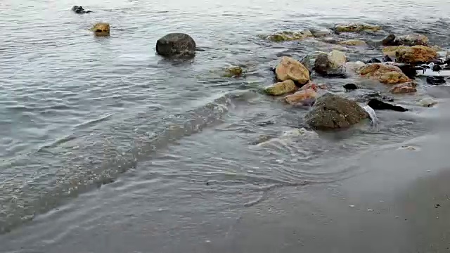 近距离的小波浪在岩石上的白色沙滩海岸视频素材