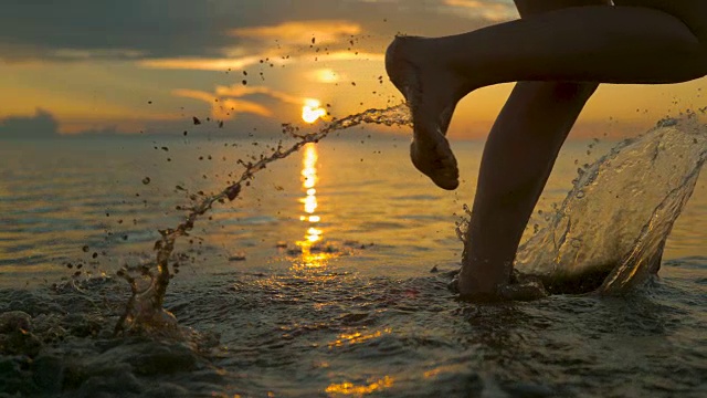 近距离观察:一个面目全非的女人在慢跑，浑浊的海水溅起水花。视频素材