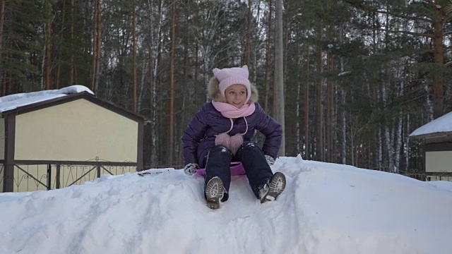 小女孩在雪山上玩雪橇视频素材