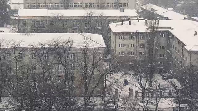 城市里降雪的慢动作。冬天好背景。冬天视频素材