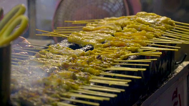 泰国街头小吃的炭炉烤猪肉棒视频素材