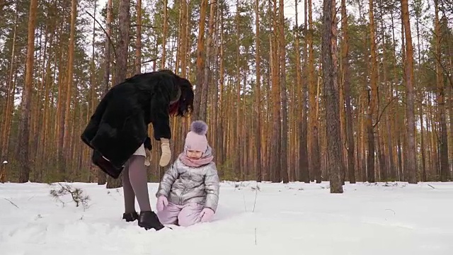 小女孩躺在雪地上，慢动作视频素材