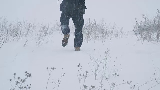 一个年轻人正穿过暴风雪视频素材