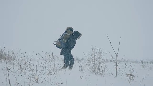 一个年轻人正穿过暴风雪视频素材