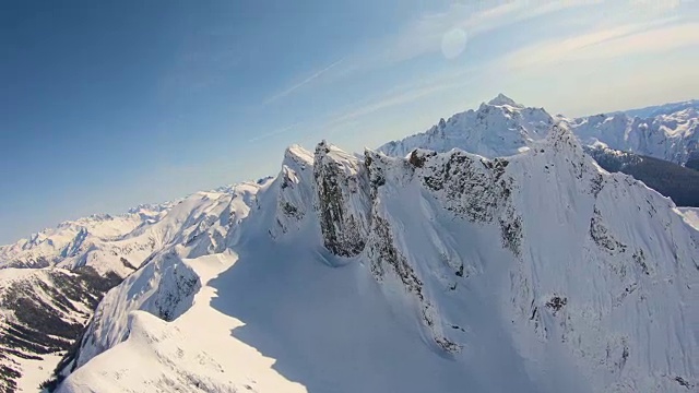 史诗航空镜头飞行近雪覆盖的锯齿山山脊后面的舒克山喀斯喀特山华盛顿州Whatcom县的尖峰视频素材