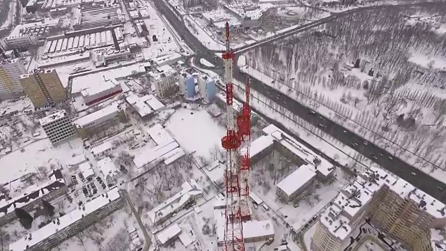 无人机正在一座现代通信塔、建筑物和道路上空飞行视频素材