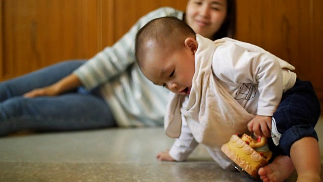 妈妈和她的宝宝在家里的地板上玩视频素材