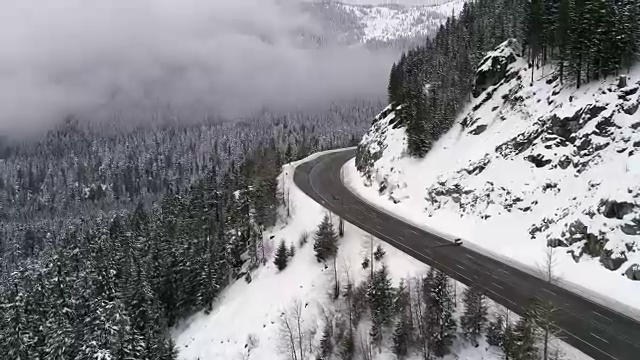 直升机拍摄旅行在积雪覆盖的山路视频素材